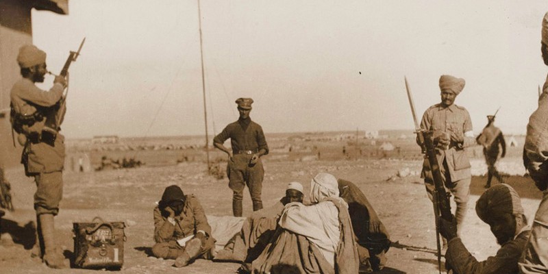 Indian Army soldiers stand guard over a group of wounded Bedouin soldiers at Mersa Matruh in western Egypt, 1915