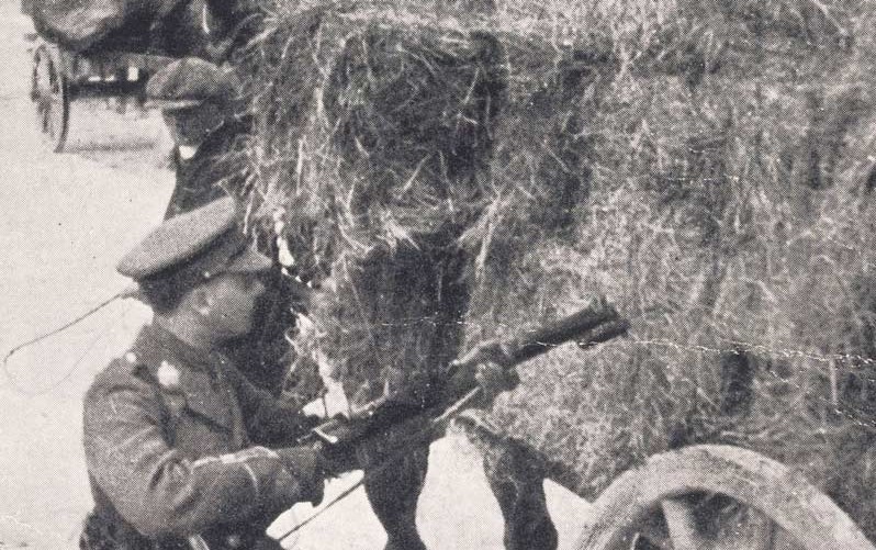Photograph of a British officer searching a hay cart for rebels or ammunition with a rifle and bayonet, May 1916