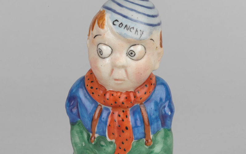 'Conchy' - a satirical ceramic figure from around 1916, criticising conscientious objection. The figure has his hands in his pockets, which for a soldier, is a disruption of army discipline.